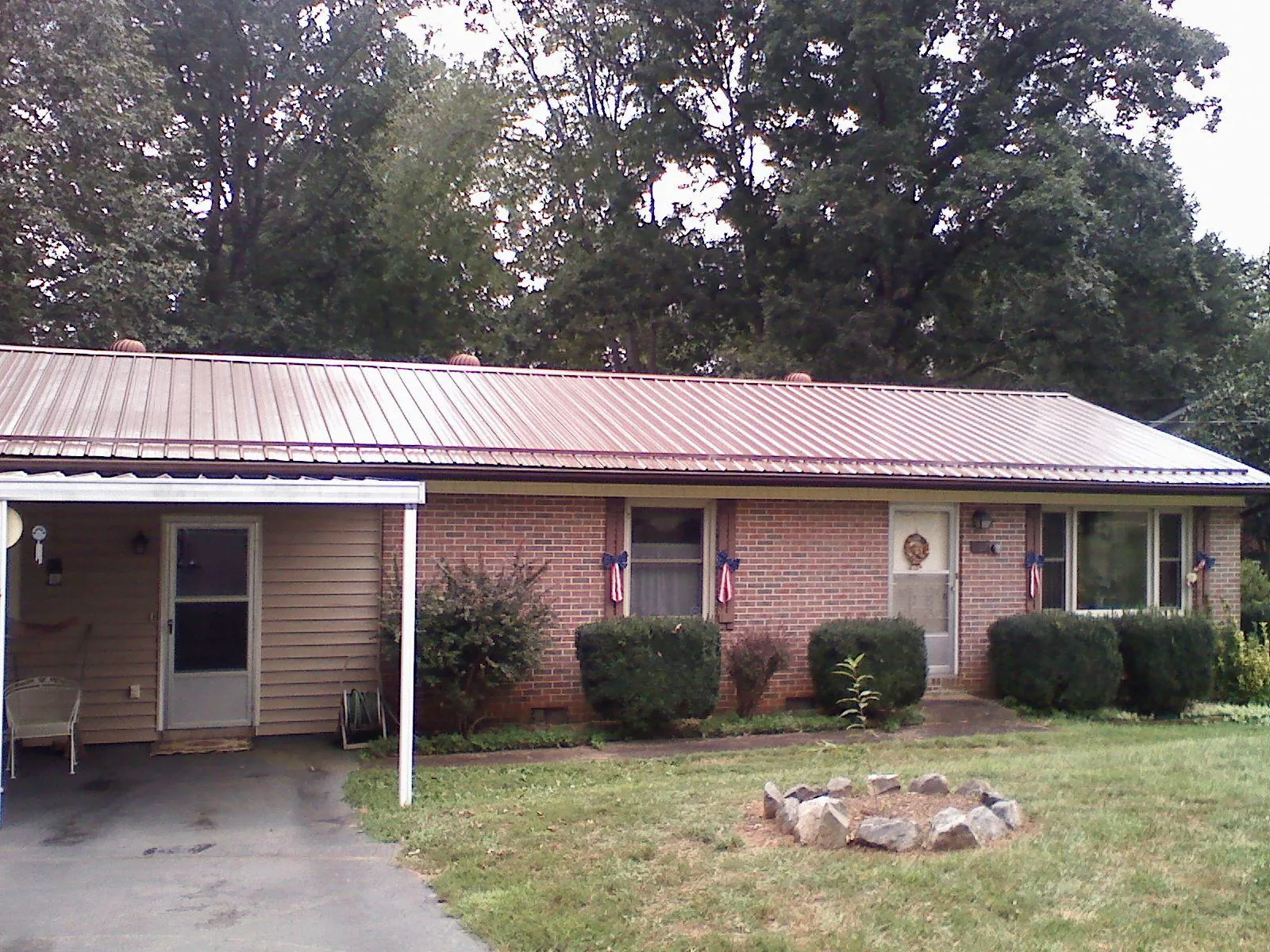 Bronze metal roof and carport on a brick ranch home — Roof Repair work by our crew in Luverne